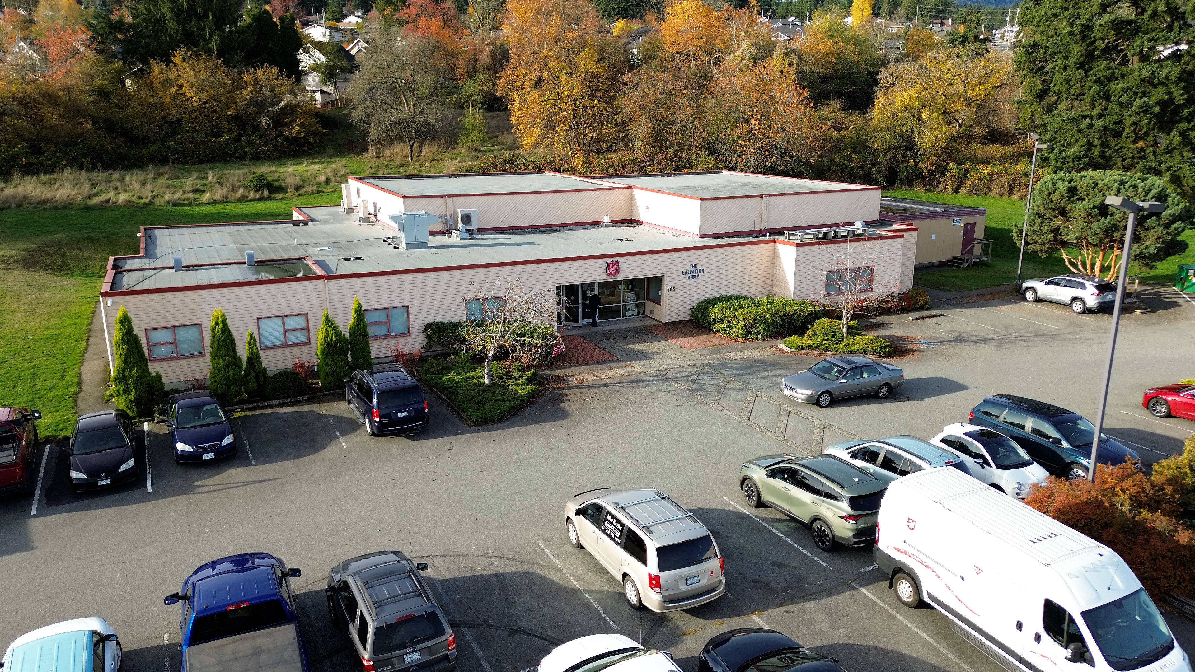 aerial shot of building, vehicles in parking lot
