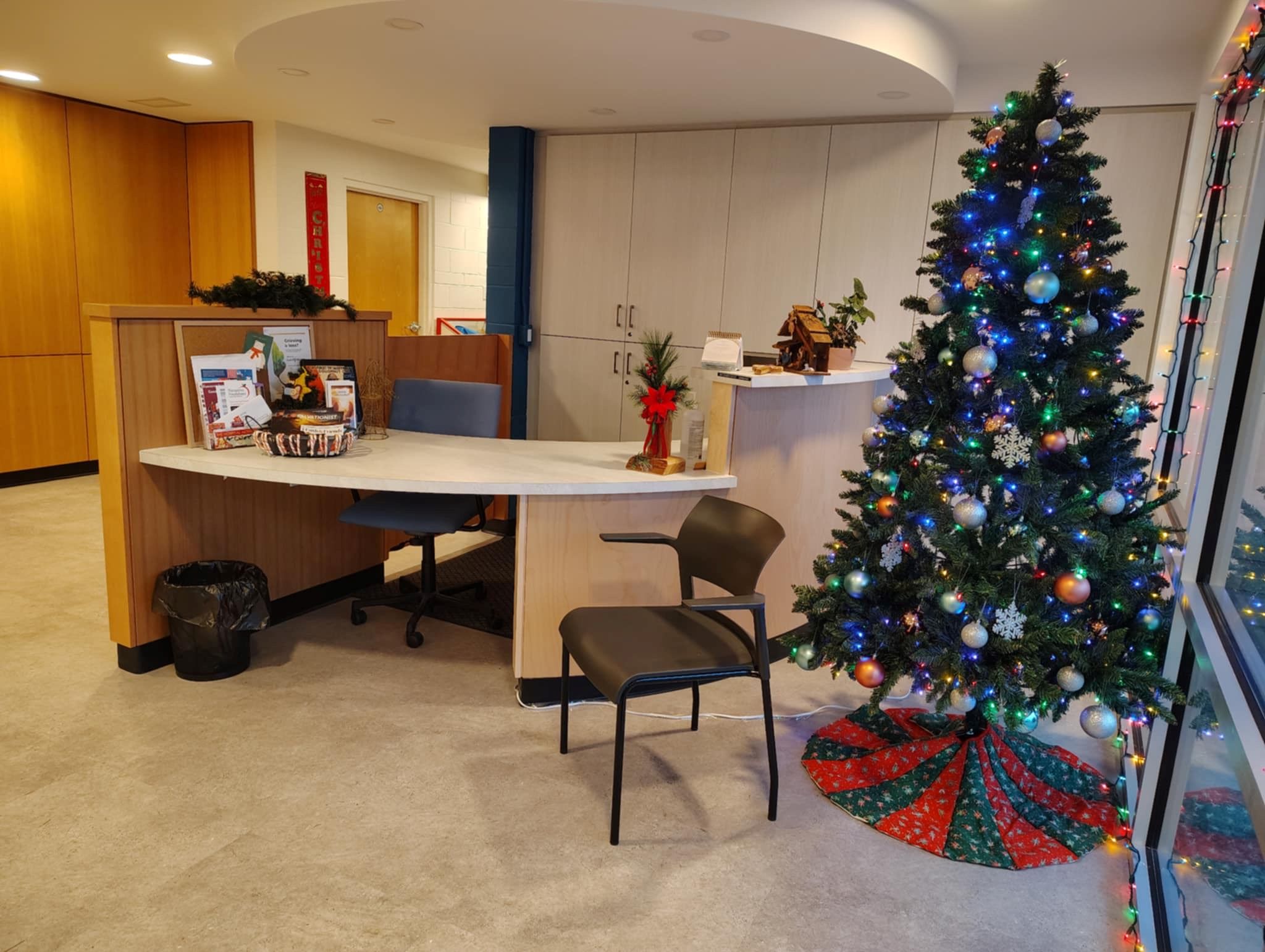 Office reception area at Nanaimo Community Church, with a service desk, seating area, and a decorated Christmas tree.